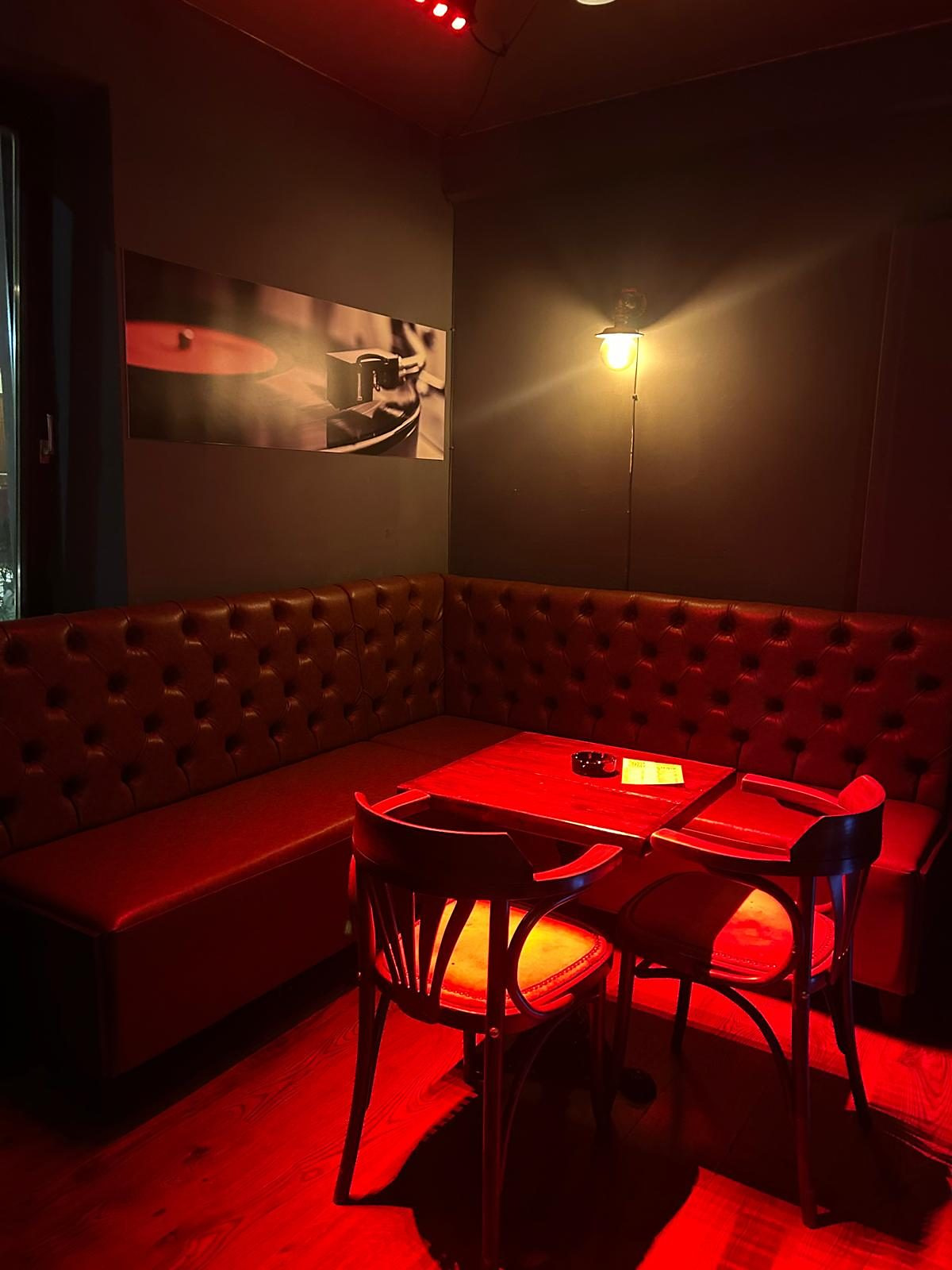 Tufted leather booth and small round table inside the bar