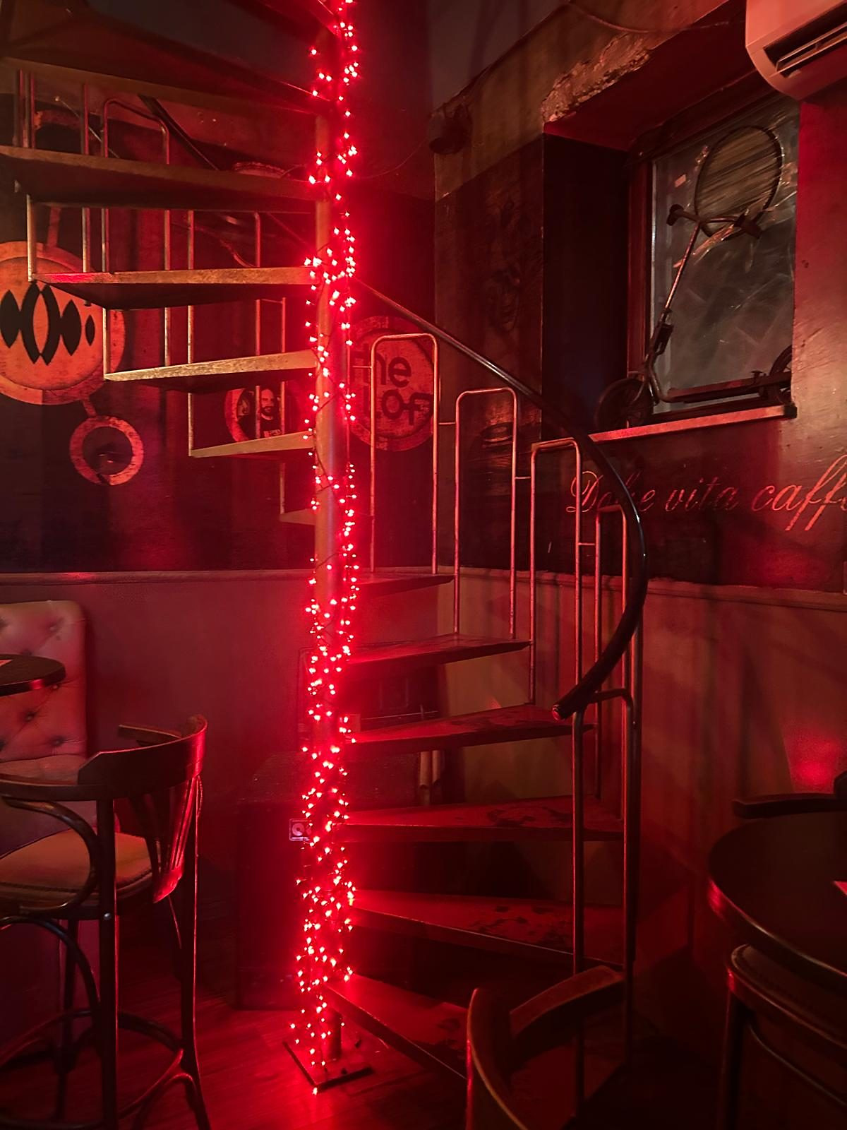 The spiral staircase wrapped in red fairy lights